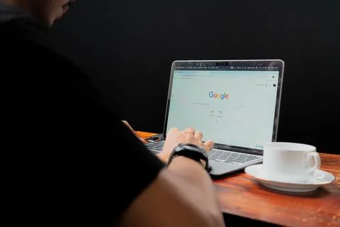 Close up view of the Google website on a laptop screen operated by an adult m Stock Photos
