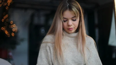 Close up view of gorgeous long-haired blonde woman actively opening gift. Style Stock Footage 104559987