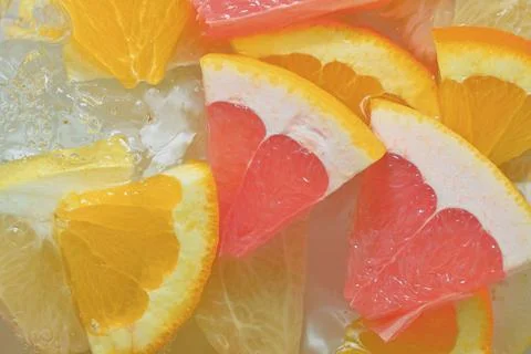 Close-up view of the grapefruit, orange fruit and honey pomelo slices in wa.. Stock-Fotos