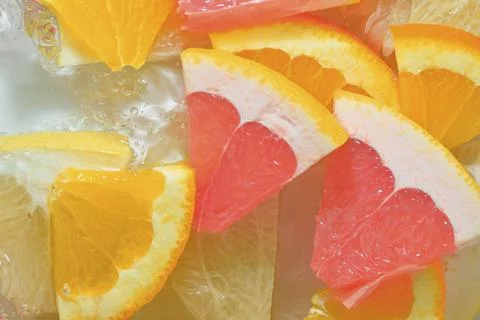 Close-up view of the grapefruit, orange fruit and honey pomelo slices in wa.. Stock-Fotos