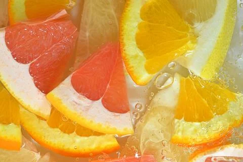 Close-up view of the grapefruit, orange fruit and honey pomelo slices in water Stock-Fotos