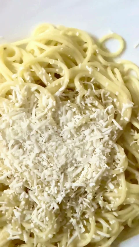 Close up view of grated cheese on hot spaghetti Vidéo 334593152