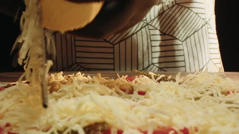 Close view of grated cheese spilling over meats with cozy atmosphere Video stock 331865286