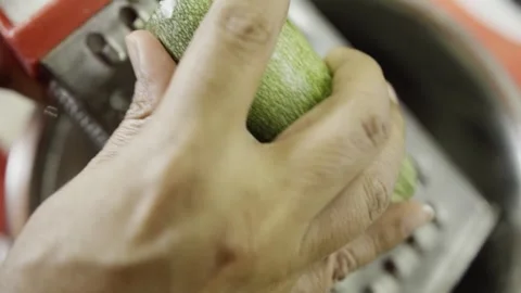 Close Up View of Grating Fresh Zucchini for Homemade Meal Preparation in Stock Footage 337497636