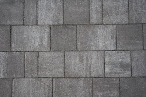 Close-up view of a gray concrete pavement surface featuring textured square 스톡 사진