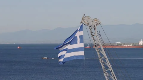 Close view of a Greek flag fluttering from a ship's rigging, with calm gulf Stock Footage 340138158