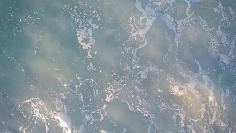 Close view on the green and blue sea, a wave rolls, makes patterns with foam. Stock Footage 79448506
