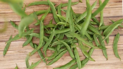 Close view of green beans falling over wooden background Video stock 159638179