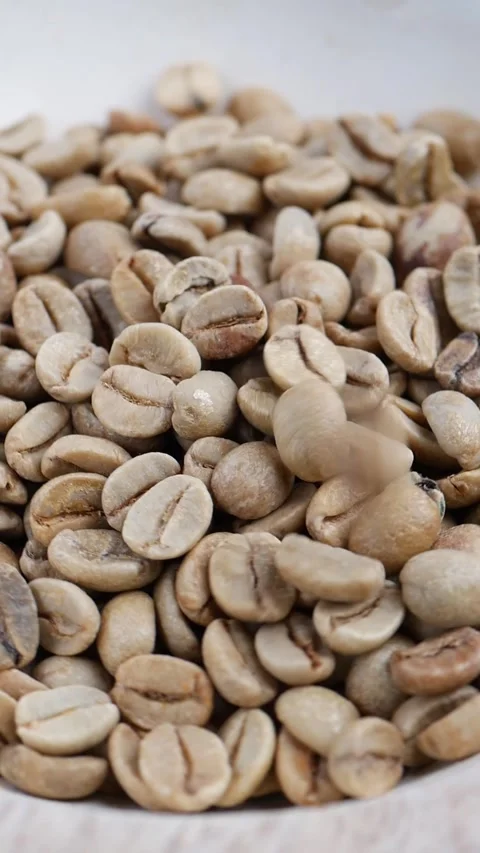 Close view of green coffee beans piled in a bowl before roasting Stock Footage 347938494