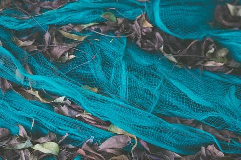 Close-up view of green nylon multi colorful bright fish nets in a pile of dry Stock Photos