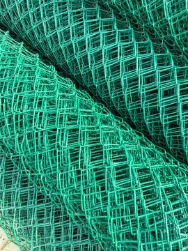 Close-up view of green plastic mesh material stacked on a surface in a work.. Stock Photos