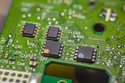 Close-up view of a green printed circuit board featuring multiple integrate.. Stock Photos