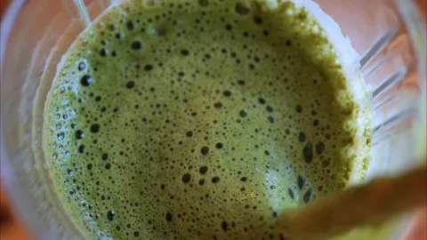 A close up view of a green smoothie being blended in a mixer with a lot of .. Stock-Footage 339382682