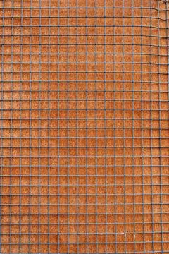 Close view of a grid pattern on a surface made of brown material surrounded.. Foto stock