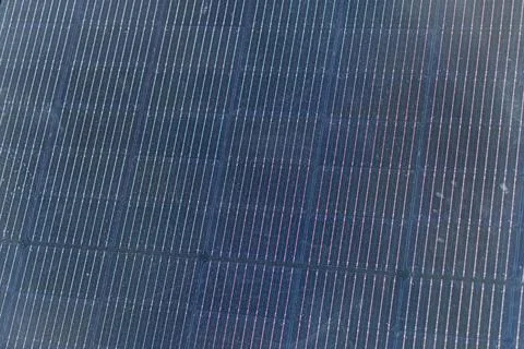 Close-up view of a grid of solar panels, arranged in varying sizes and spacin 스톡 사진