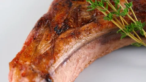 Close-up view of grilled pork chop, decorated with thymus vulgaris Stock Footage 87606244