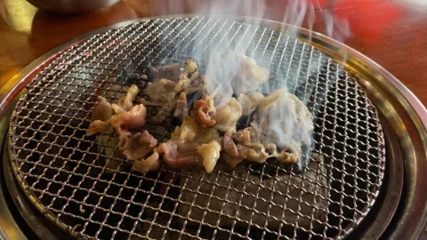 Close up view of grilling thin beef slices on stainless steel grill Stock Footage 307104867