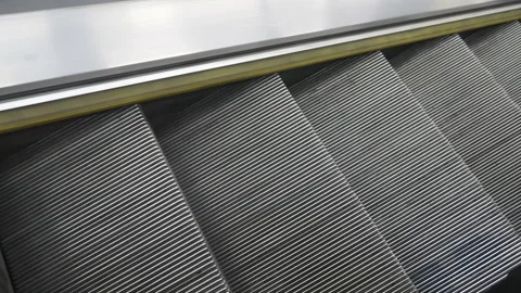 Close-up view of grooved metal steps on a moving escalator.  Stock Footage 345267417