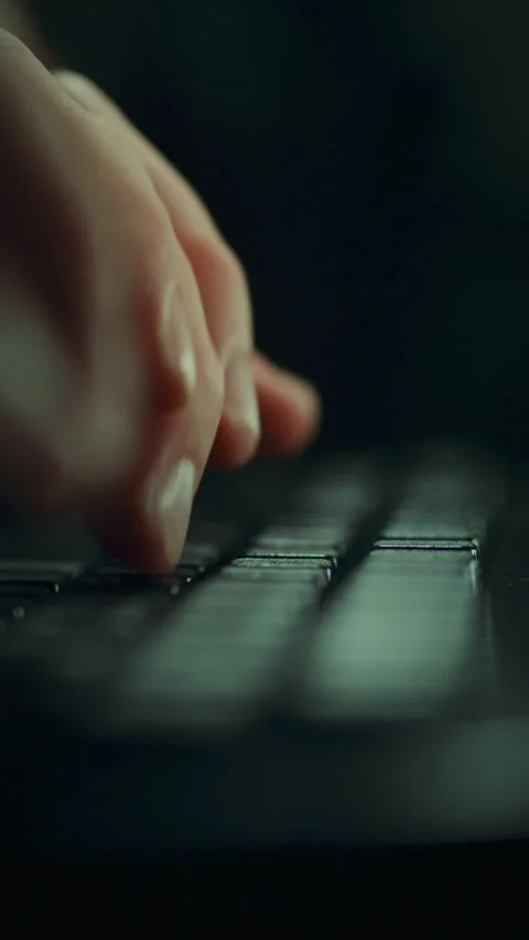 Close-up view of a hacker programmer focused on coding in a dimly lit enviro Stock Footage 331533796
