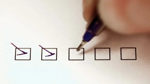 Close-up view of hand checking multiple boxes with a pen on a paper form Stock Footage 304985374