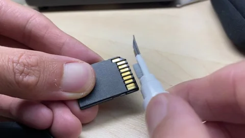 Close up view hand cleaning SD Card slot with brush tool at home. Video stock 249494715