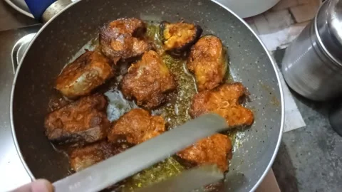 Close up view of hand frying fish cutlet in oil pan at home Stock Footage 163138574