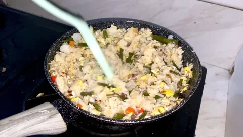 Close-up view of a hand frying fried rice on a frying pan Stock Footage 293646466