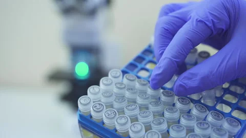 Close-up view of a hand in glove take out and examine small test tubes with Stock Footage 159065224