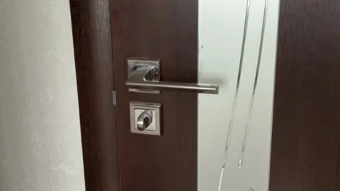 Close-up view of a hand grabbing a modern chrome handle and opening a dark brown Stock Footage 321700149