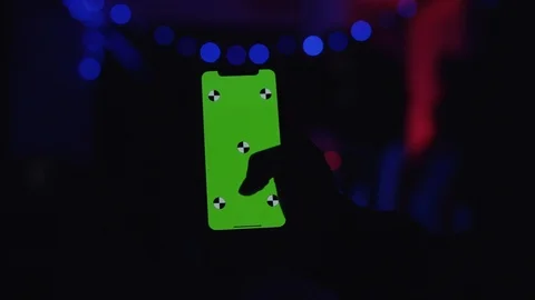 Close up view of a hand holding green chroma key screen on party in neon lights Stock Footage 111221206