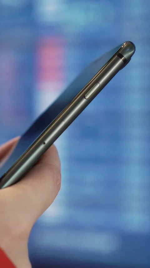 Close-up view of a hand holding a smartphone with visible buttons and screen Stock Footage 329201773