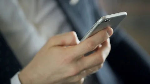 Close-up view on hand of man with phone texting message indoors. Stock Footage 79039674