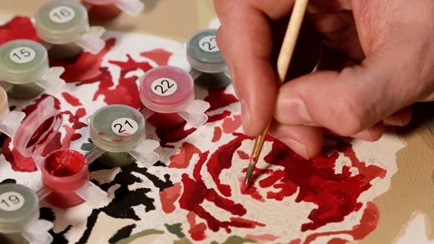 Close up view of a hand painting with a small brush on numbered canvas. Stock Footage 151250532