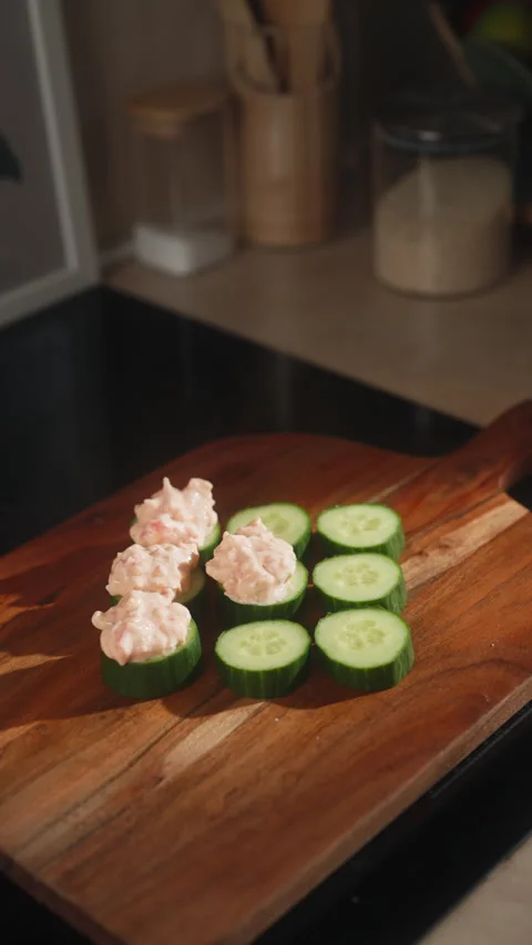 Close Up View of Hand Placing Crab Salad Mixture on Cucumber Slices with Spoon Stock Footage 348791269