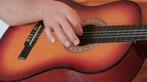 A close-up view of a hand playing guitar. Music, creativity, instrumental skills Stock Footage 279669278