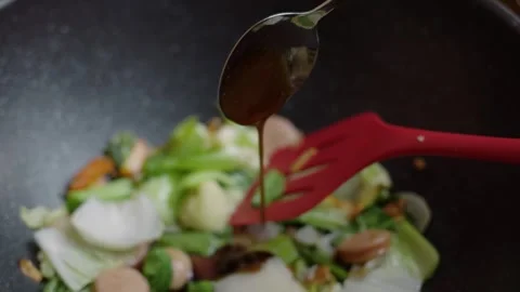 Close-up view of Hand pour oyster sauce into the dish. Capcay or chop suey .. Stock-Footage 329703955