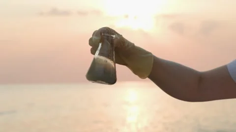 Close up view of hand in rubber glove testing sample flask of dirty water Video stock 255283146