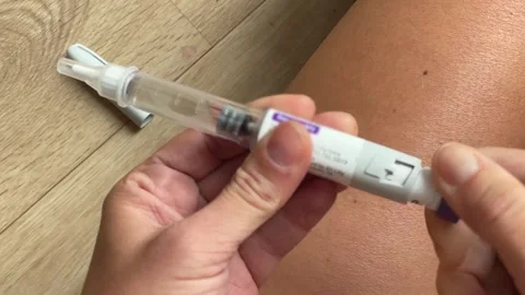 Close-up view of a hand selecting a doze on  a tirzepatide injection pen  Stock Footage 289733329