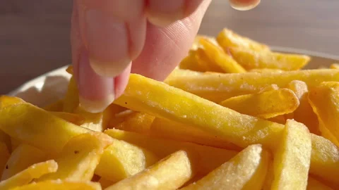 Close up view of hand taking hot crispy French fries from plate in cafe. Closeup Stock Footage 263969648