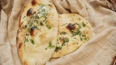 Close-up view of handmade naan bread seasoned with oil and coriander. Stock Footage 282766386