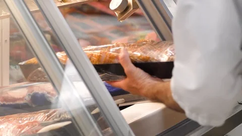 Close up view as hands are placing bacon slices inside the butchery showcase Stock-Footage 104950322