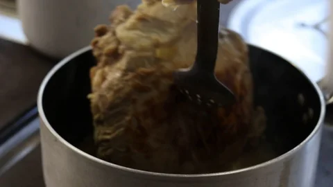 Close-up view of the hands of the chef preparing braised beef in the pot Stock Footage 122160899