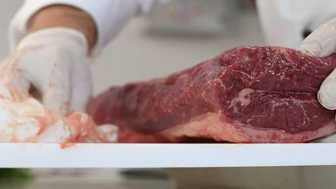 Close-up view of the hands of the chef preparing and cleaning the cut of meat on Stock Footage 122172017