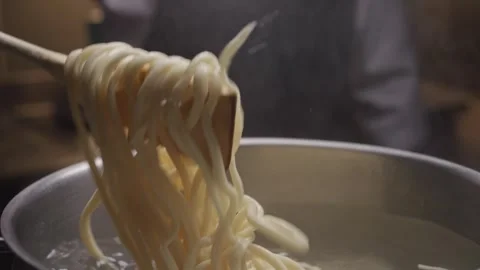 Close-up view of hands of chef stirs the pasta in the pan. Stock Footage 317368058