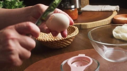 Close-up view of hands cracking a fresh egg into a small glass bowl during food 스톡 동영상 347175280