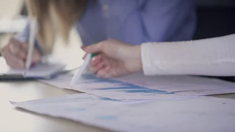 Close-up view on hands of employees, analyzing statistics indoors. Video stock 77332692