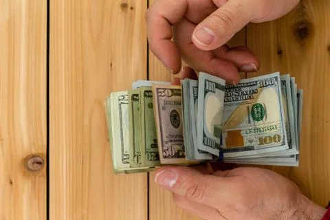 Close up view of hands holding bundle of banknotes Stock Photos