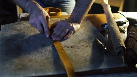 Close-up view of hands of a leather cutting leather sheet to make leather Stock Footage 71389378