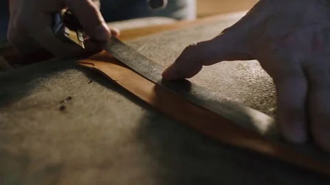 Close-up view of hands of a leather cutting leather sheet to make leather Stock Footage 71389400