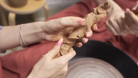 A close-up view of the hands of a man and woman sculpting clay . Stock Footage 128552746